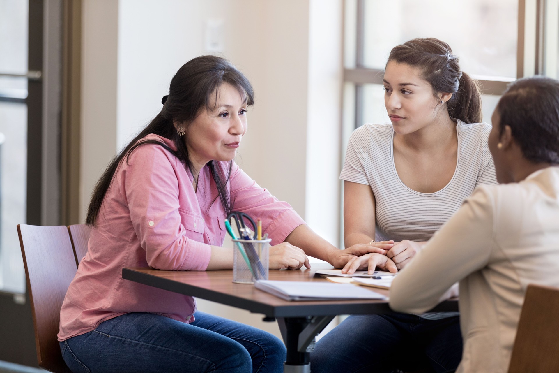 Hispanic woman talks with bank officer