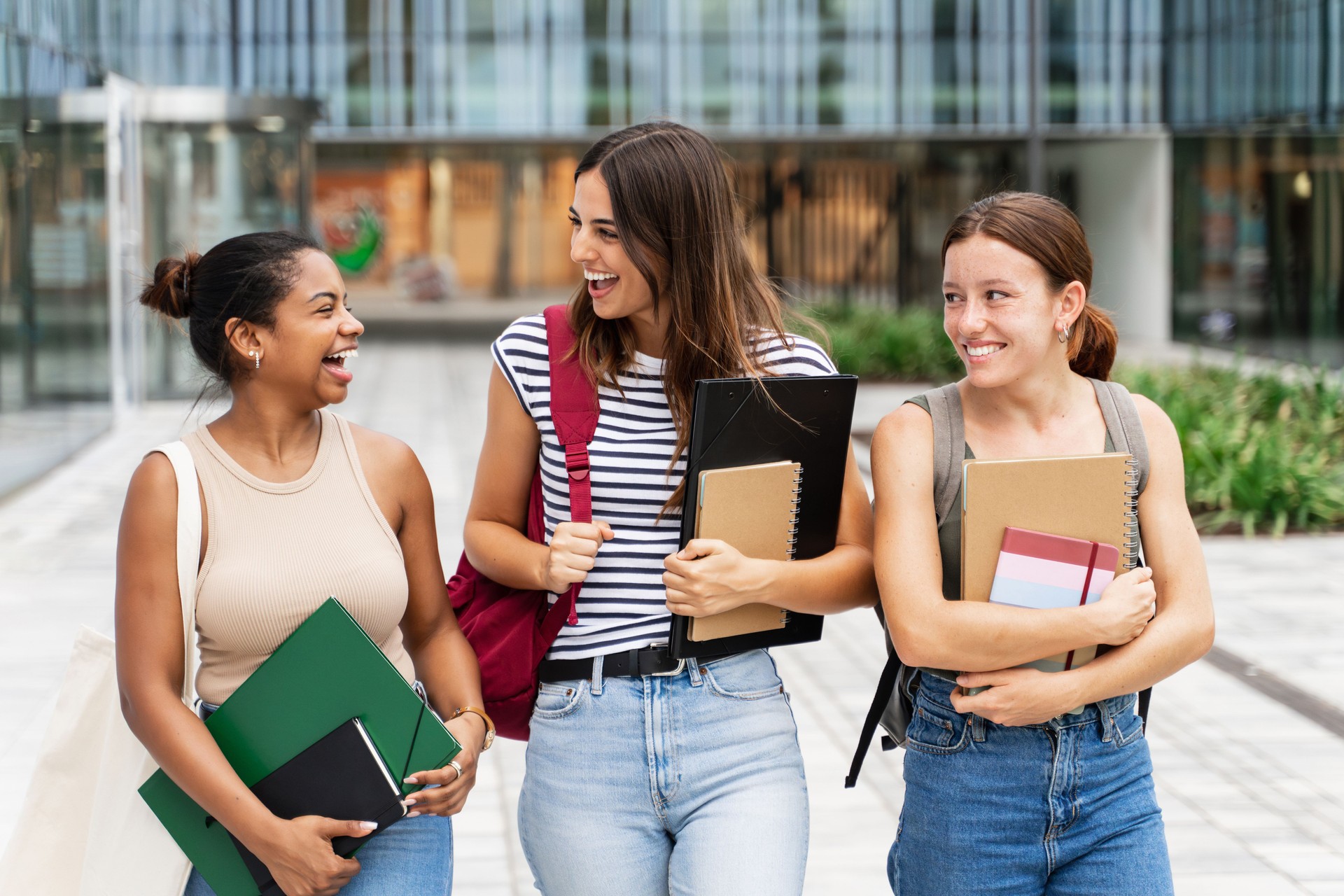 Estudiantes universitarios internacionales caminando fuera del edificio de la Facultad de Economía y Administración de Empresas